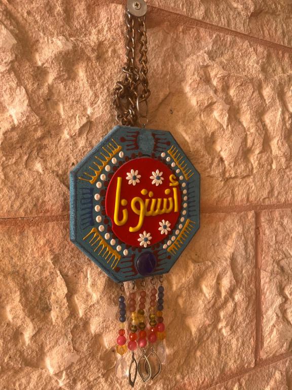 a sign on a wall with beads on a chain at Lozi House Cozy Stay in Al Azraq ash Shamālī