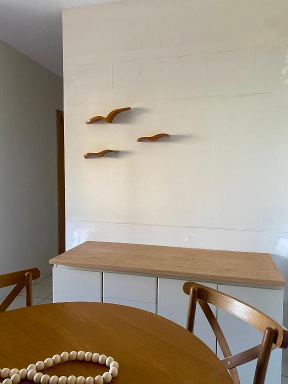 a table and chairs with birds on the wall at Ap charmoso in Mossoró