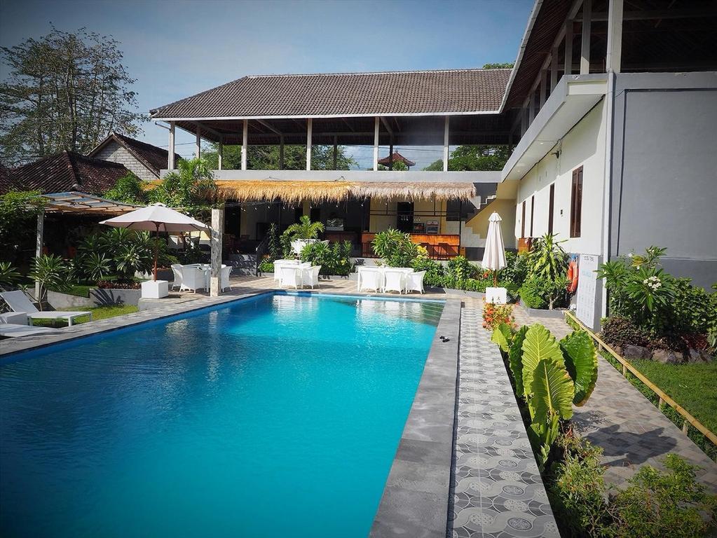 a swimming pool in front of a house at Scuba Tribe Bali dive-resort in Tulamben