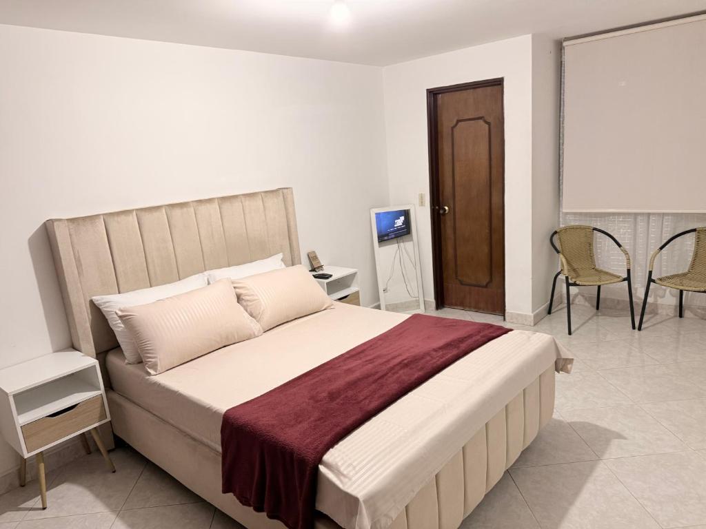 a bedroom with a bed and a table and chairs at Alojamiento Laureles la 33 in Medellín