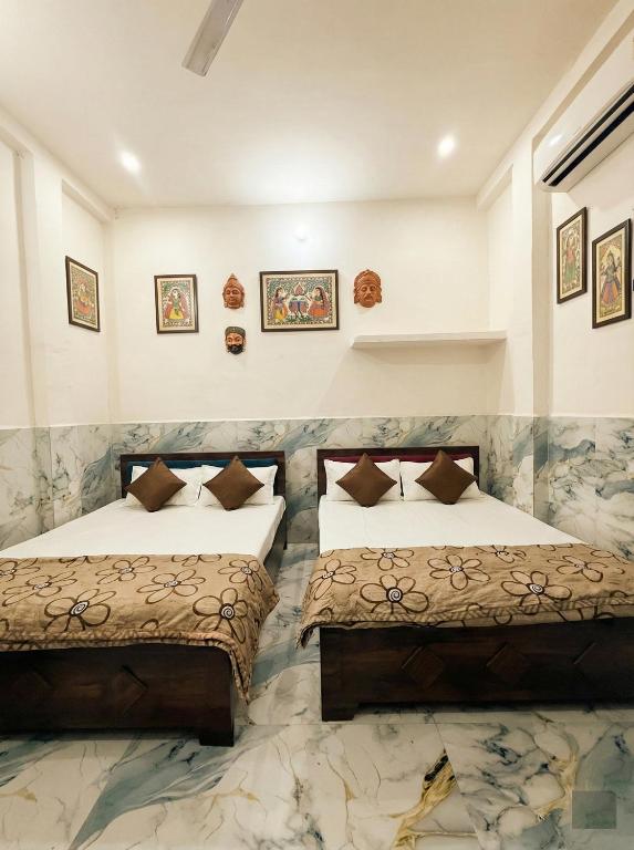 two beds in a hotel room with two beds at Samriddhi UrbanStay in Ayodhya