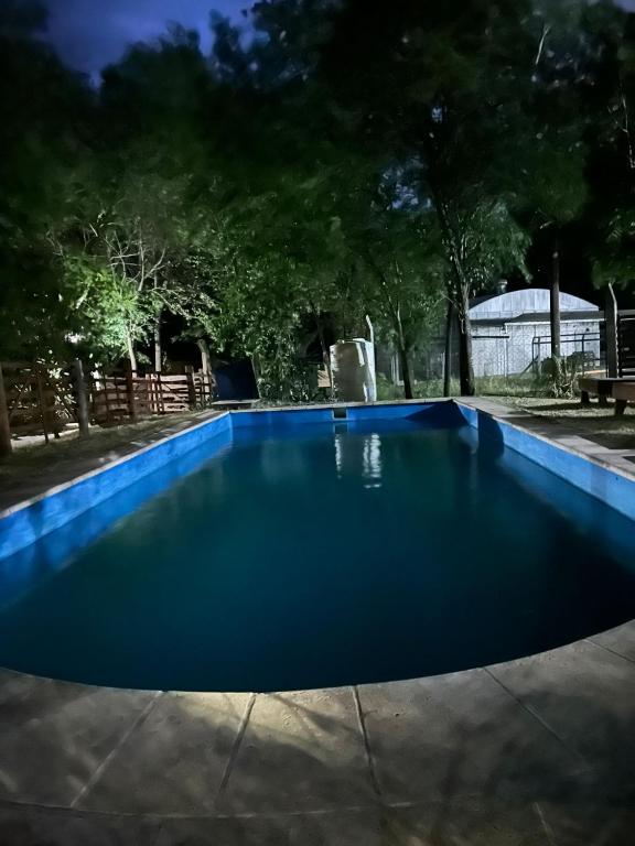 a blue swimming pool at night at Cabañas El Oasis del Peñón in Casa Grande
