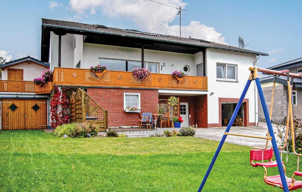 a house with a yard with a swing at Beautiful Apartment In Reifferscheid in Reifferscheid