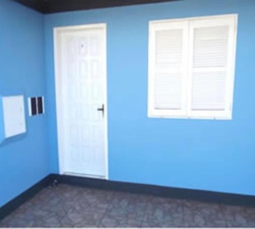 a blue room with a door and a window at Pousada Moschen in Passo de Torres