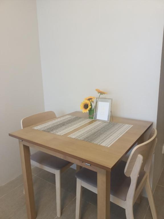 a wooden table with a vase of flowers on it at Carol sweet room in Cebu City