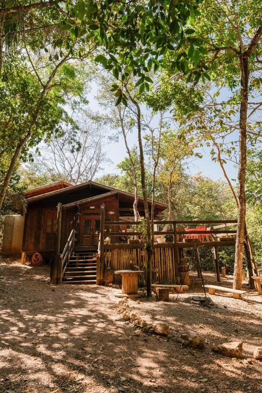 a log cabin with a porch and stairs to it at Casa de Madeira - Sao Jorge GO in Sao Jorge