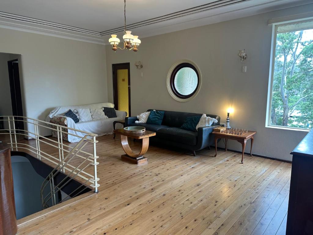 a living room with a couch and a table at Gracious 1930s Art Deco House in Gosford