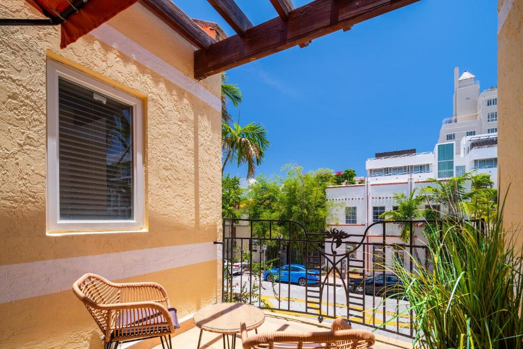 a balcony with chairs and tables and a view of a street at Kasa Impala Miami Beach in Miami Beach