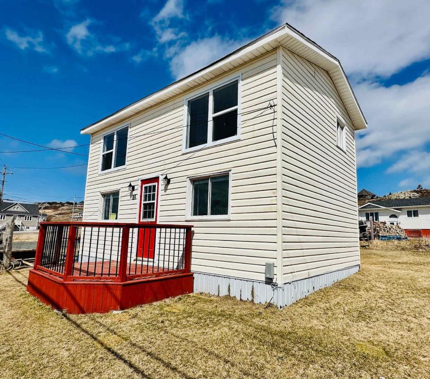 a white house with a red door at Iceberg Lookout in Twillingate