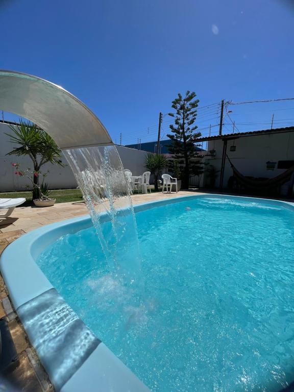 a swimming pool with a water fountain at Casa temporada frances in Marechal Deodoro