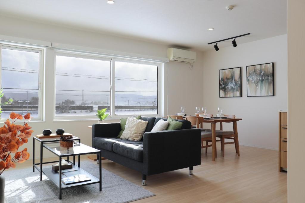 a living room with a couch and a table at Akayane Lodge by H2 Life in Nakafurano