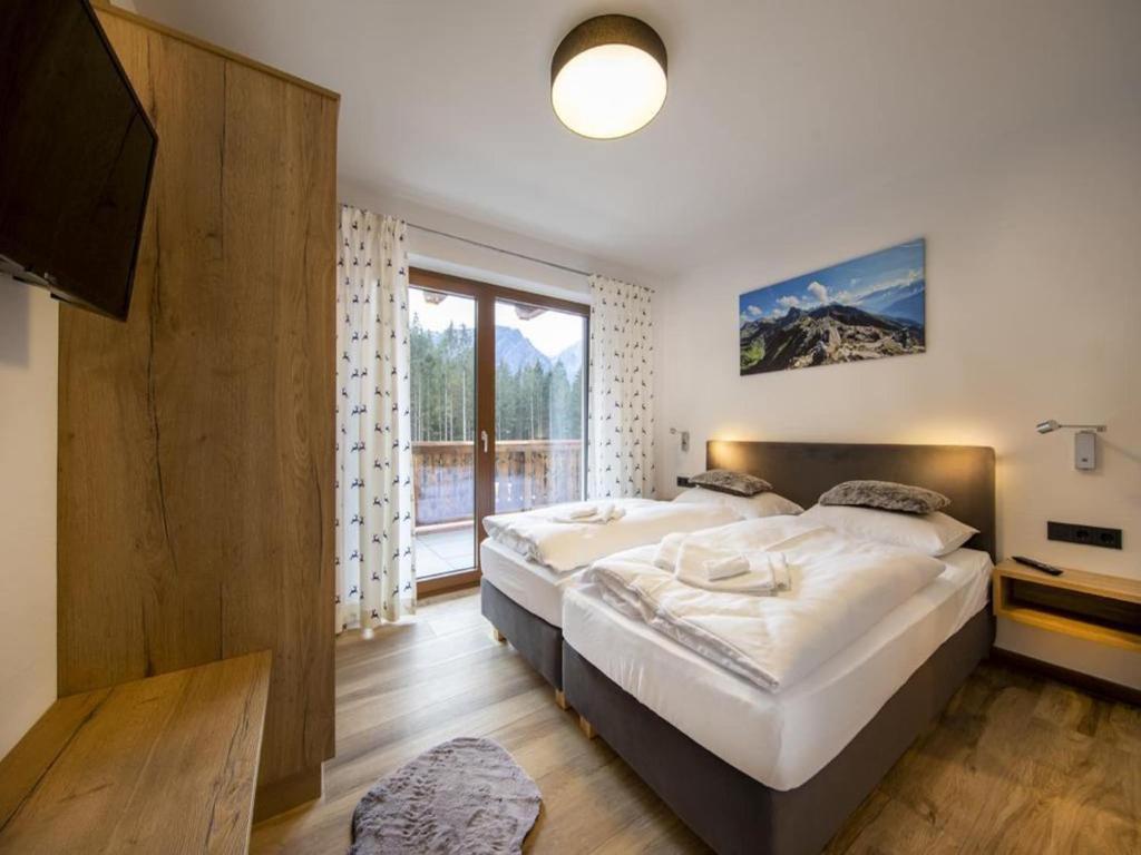 a bedroom with a large bed and a large window at Luxury alpine chalet in Neukirchen in Neukirchen am Großvenediger
