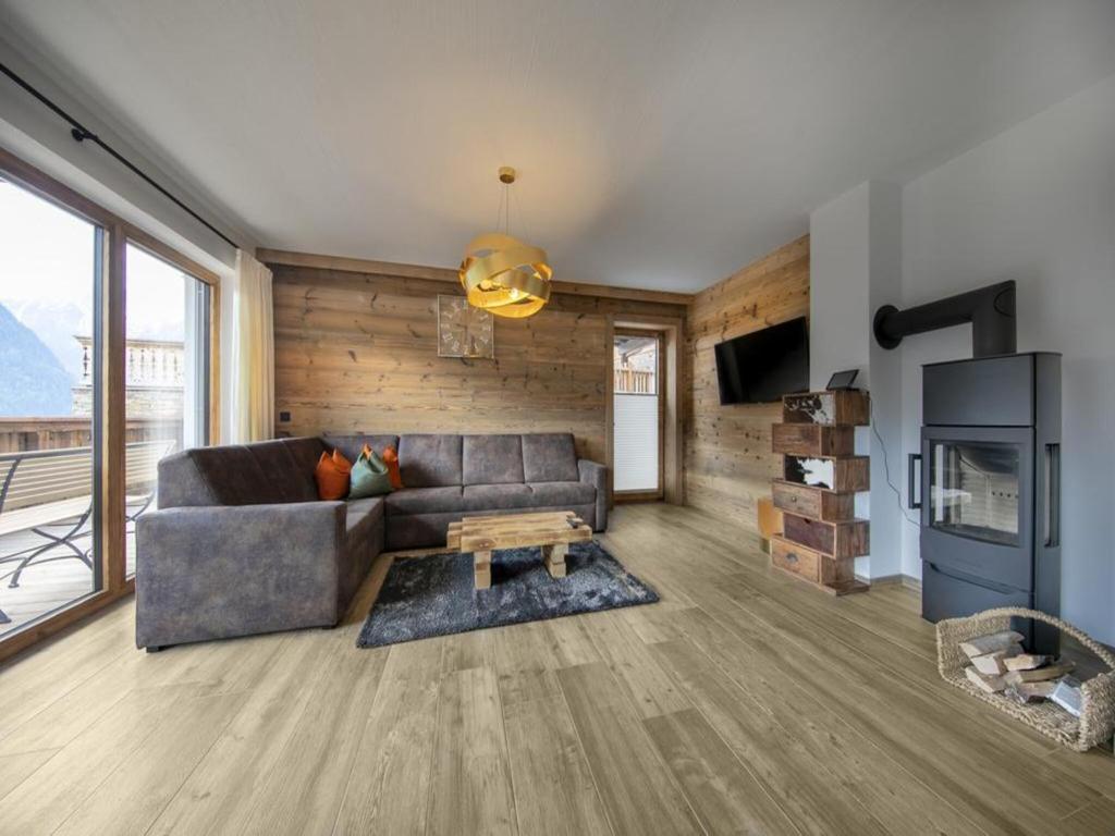 a living room with a couch and a tv at Chalet in Neukirchen for 8 people in Neukirchen am Großvenediger