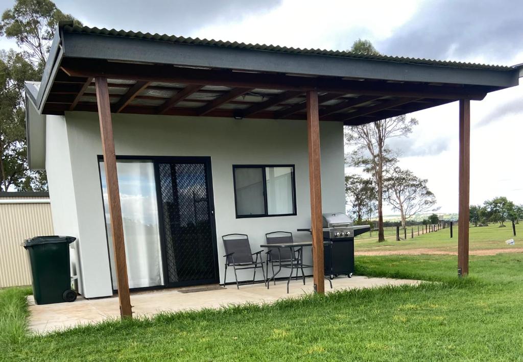 a pavilion with a table and chairs in front of a house at Hanger Ridge Cabin in Goodger