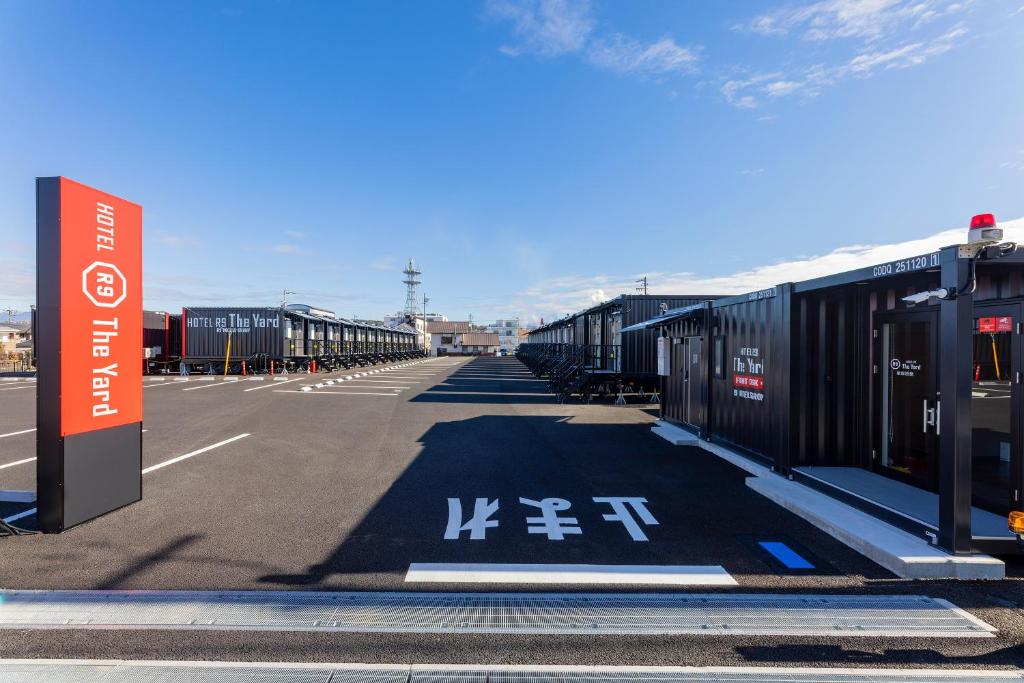 an empty parking lot with rows of shipping containers at HOTEL R9 The Yard Enabekkan in Ena