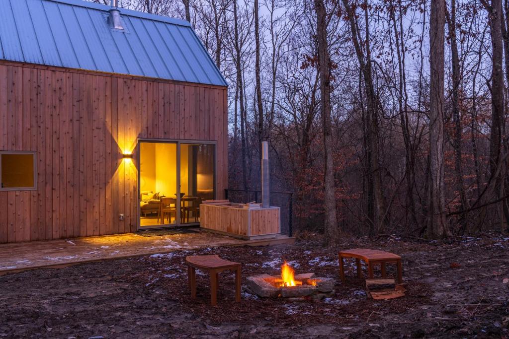 a small wooden house with a fire in front of it at The Klover in Logan