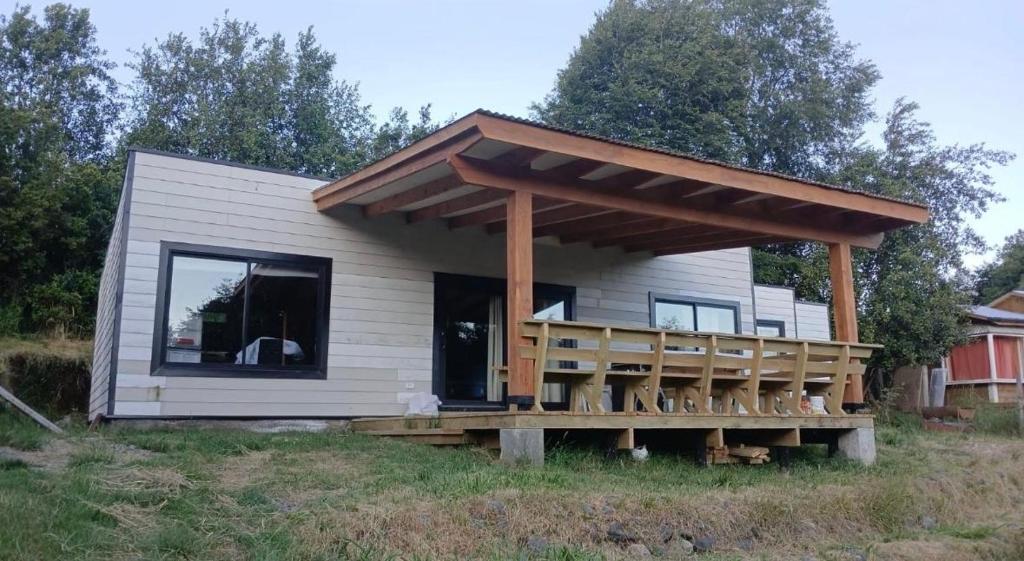 a tiny house with a porch and a deck at Casa cerca de lago Caburgua in Pucón