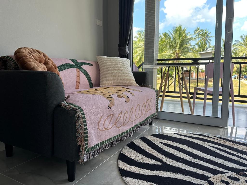a living room with a chair and a balcony at Hill View Home 2 in Chaloklum