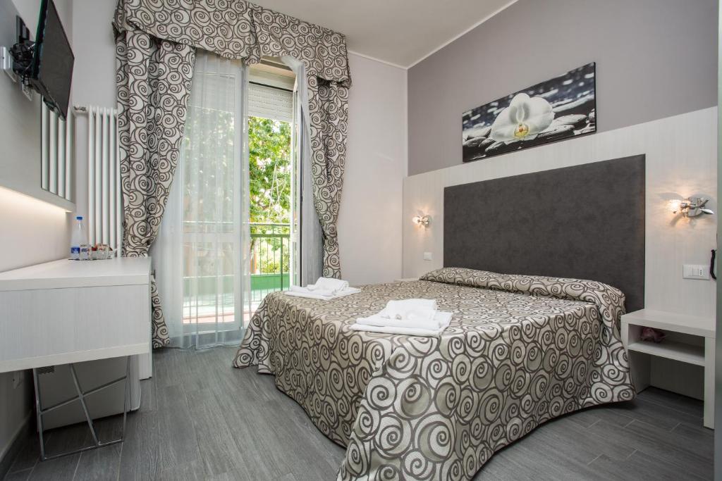 ein Hotelzimmer mit einem Bett und einem Fenster in der Unterkunft Albergo Ristorante Pozzi in Bellaria-Igea Marina