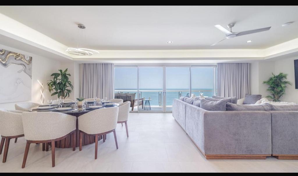 a living room with a couch and a table and chairs at Sonoran Star Signature 3-Bedroom Beachfront Luxury Condominium in Puerto Peñasco