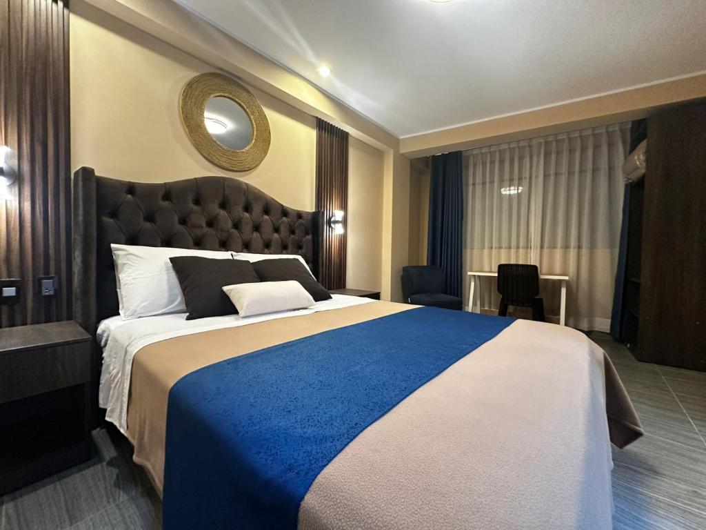 a bedroom with a large bed with a blue blanket at Gran Hotel in Yungay