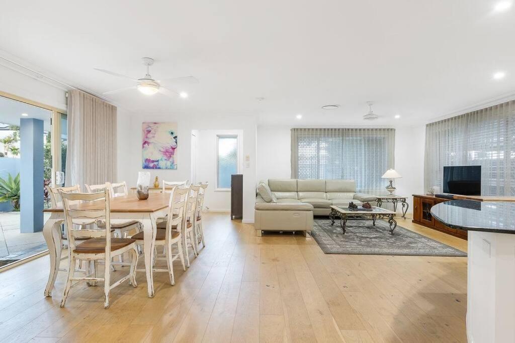 a dining room and living room with a table and chairs at Coastal House in Gold Coast