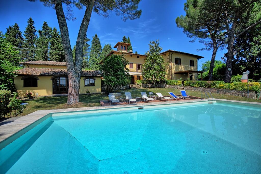 a swimming pool in front of a house at Villa Orchidea by PosarelliVillas in Certaldo