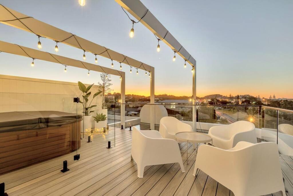 a patio with white chairs and tables on a deck at Salt Tugun in Gold Coast