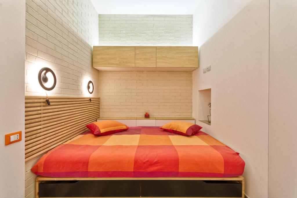 1 dormitorio con 1 cama grande con una manta colorida en Little&Cosy, en Turín