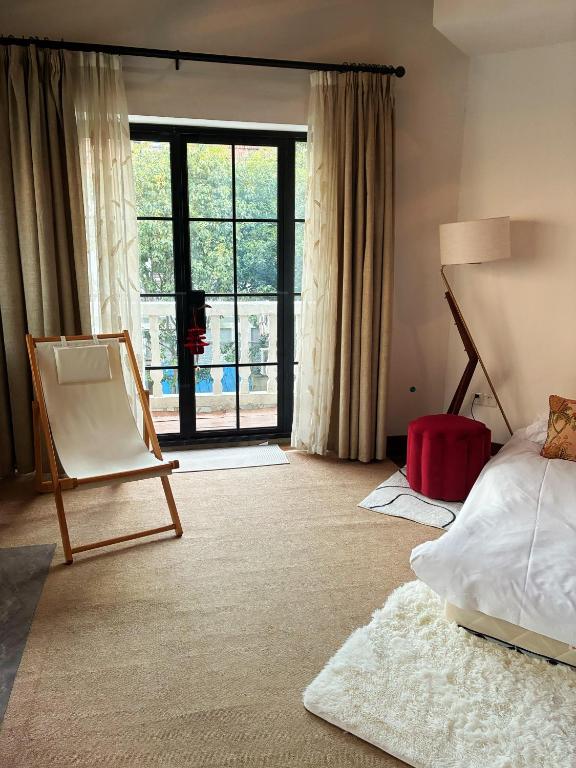 a bedroom with a bed and a large window at Shanghai Historical Forest Cabin loft With Balcony at second floor near middle Huaihai road in Shanghai