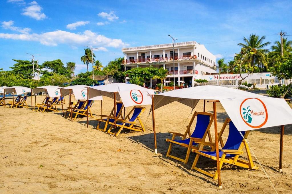 a row of chairs and umbrellas on a beach at Hotel Montecarlo by Croma in Santiago