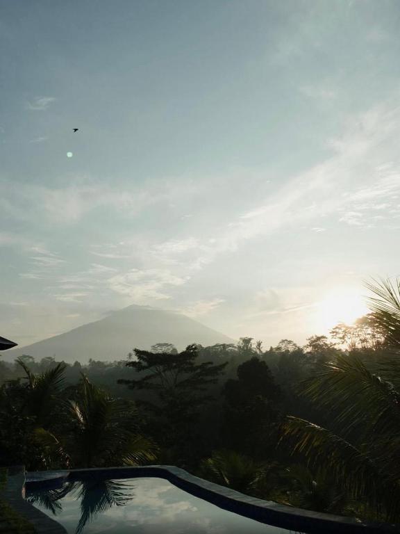a view of a mountain from a resort with a swimming pool at De Silaa House & Pool in Bangli