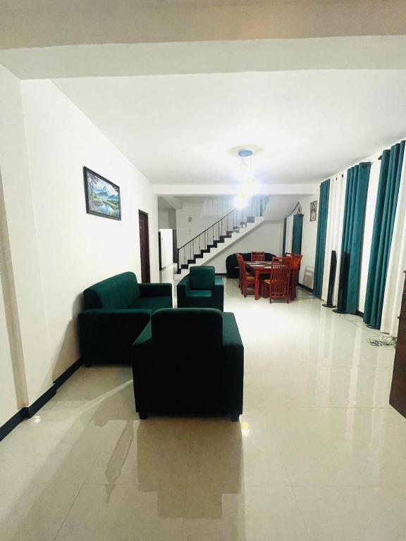 a living room with a couch and chairs and a table at Golden Paradise Transit Hotel in Katunayaka