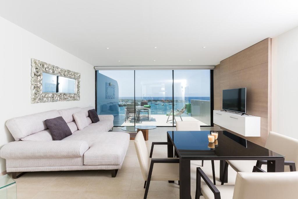 a living room with a white couch and a table at Arguineguín Bay Apartments in La Playa de Arguineguín