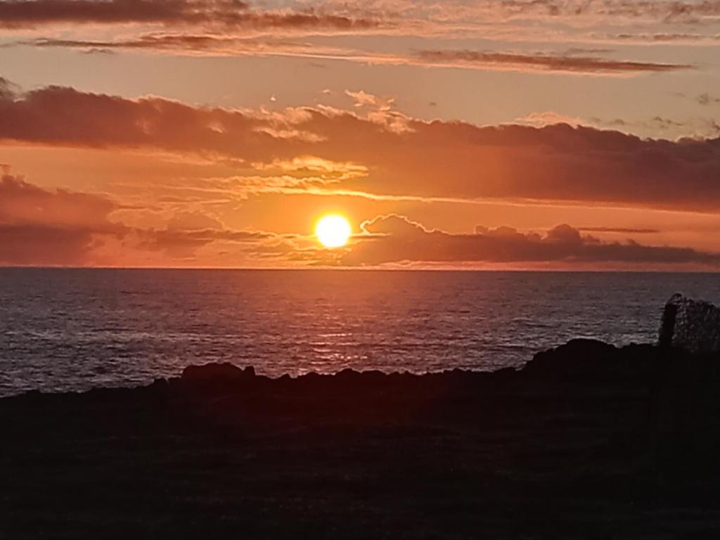 a sunset over the ocean with the sun setting at Don José in Los Molles