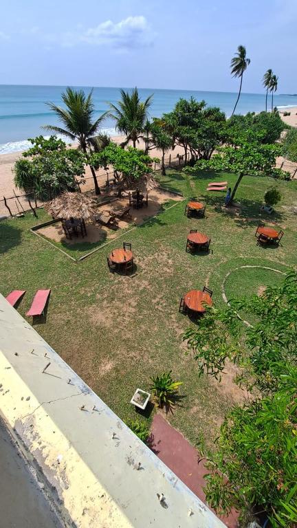 a park with benches and trees on the beach at Sea View Beach Hotel in Nilaveli