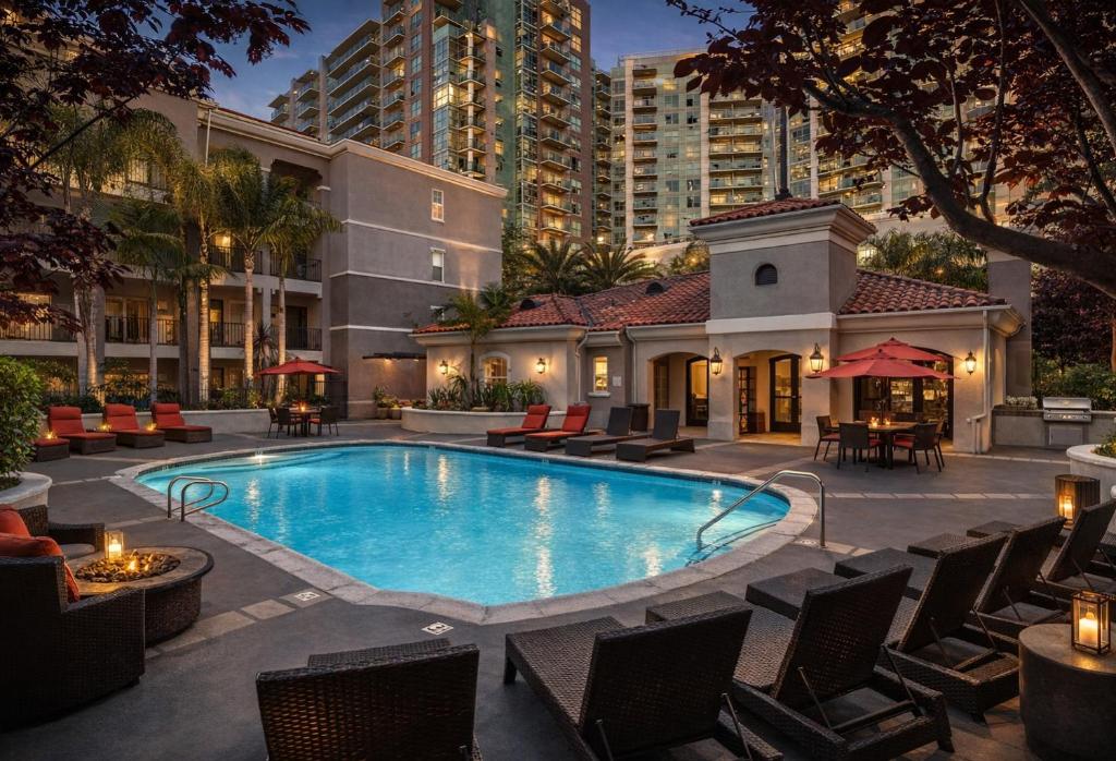 a swimming pool with chairs and a building at Modern 1 & 2 Bedroom Apartments Near Venice & MDR with Pool Gym & Cinema in Los Angeles