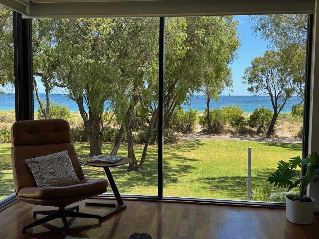 a living room with a chair and a large window at 5@CapeView, beachfront Geographe Bay in Busselton
