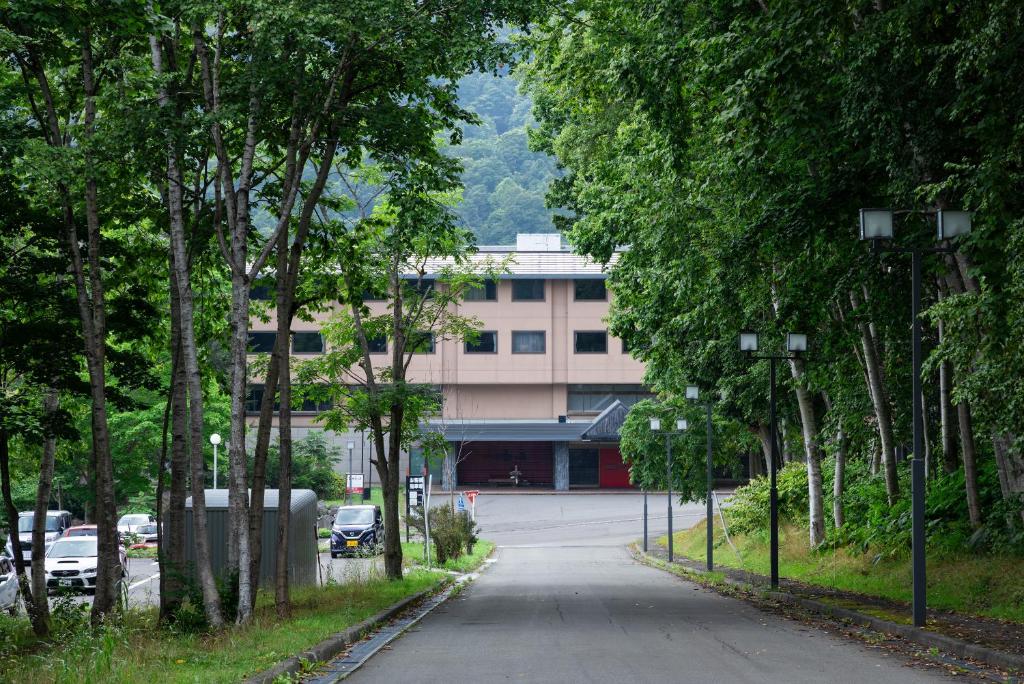 une rue vide avec des arbres et un bâtiment dans l'établissement Hotel Kanronomori, à Niseko
