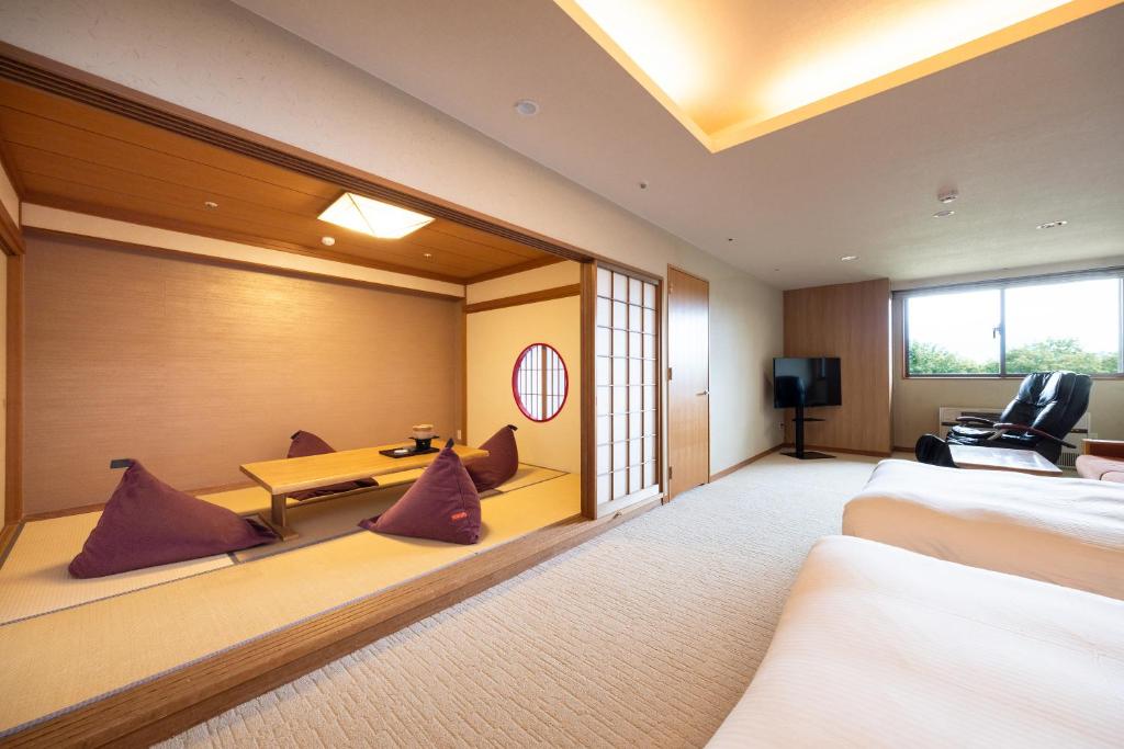 une chambre d'hôtel avec deux lits et une table dans l'établissement Hotel Kanronomori, à Niseko