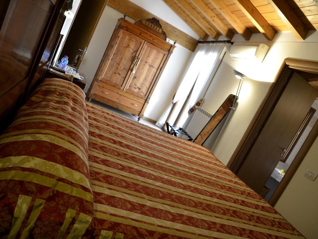 łóżko w sypialni z paskiem w obiekcie 9 Muse Bed and Breakfast w mieście Canneto sullʼOglio