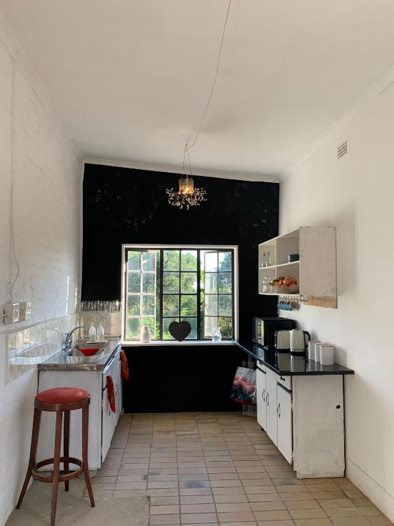 a kitchen with a counter and a window in it at The Barn, at Glenora Avenue in Somerset West