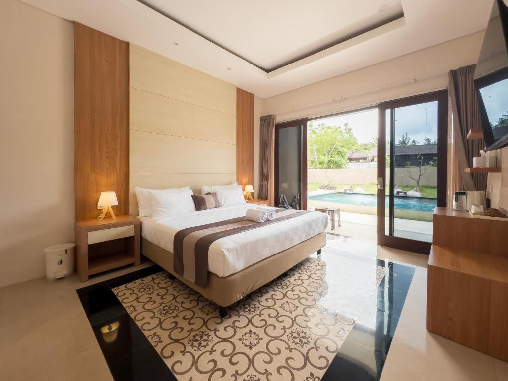 a bedroom with a large bed and a pool at Airindah Villa in Gili Islands