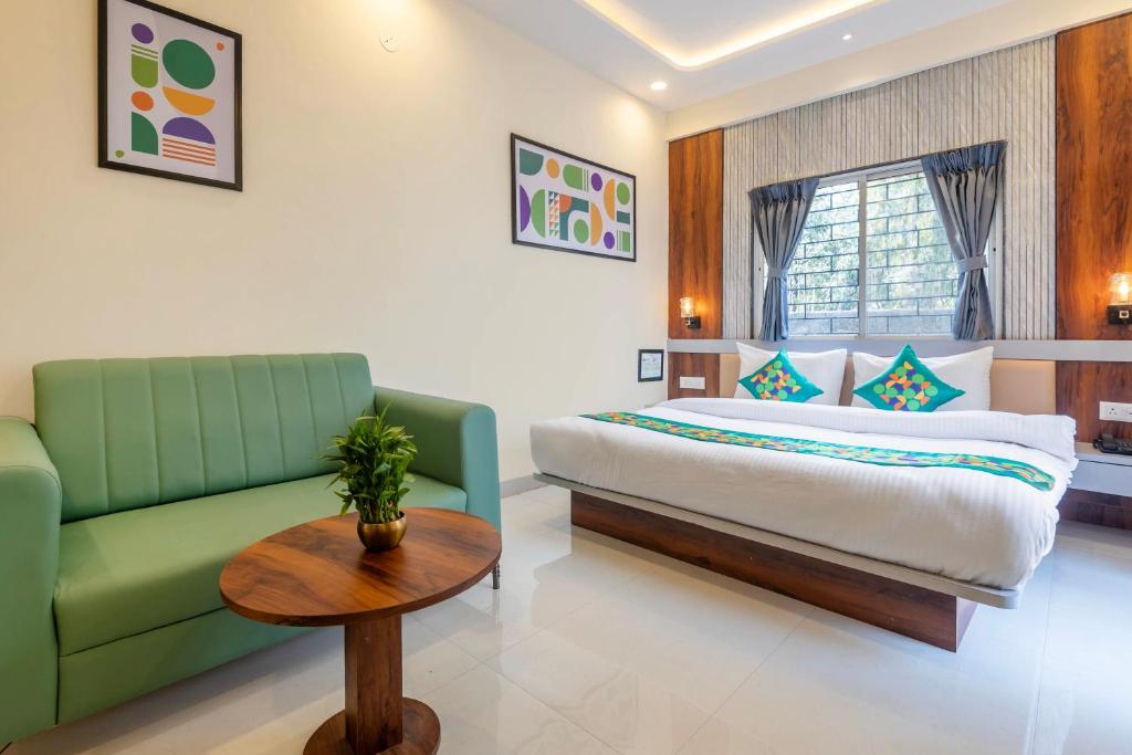 a bedroom with a bed and a couch and a table at Treebo Himalayan Homestay in Pune