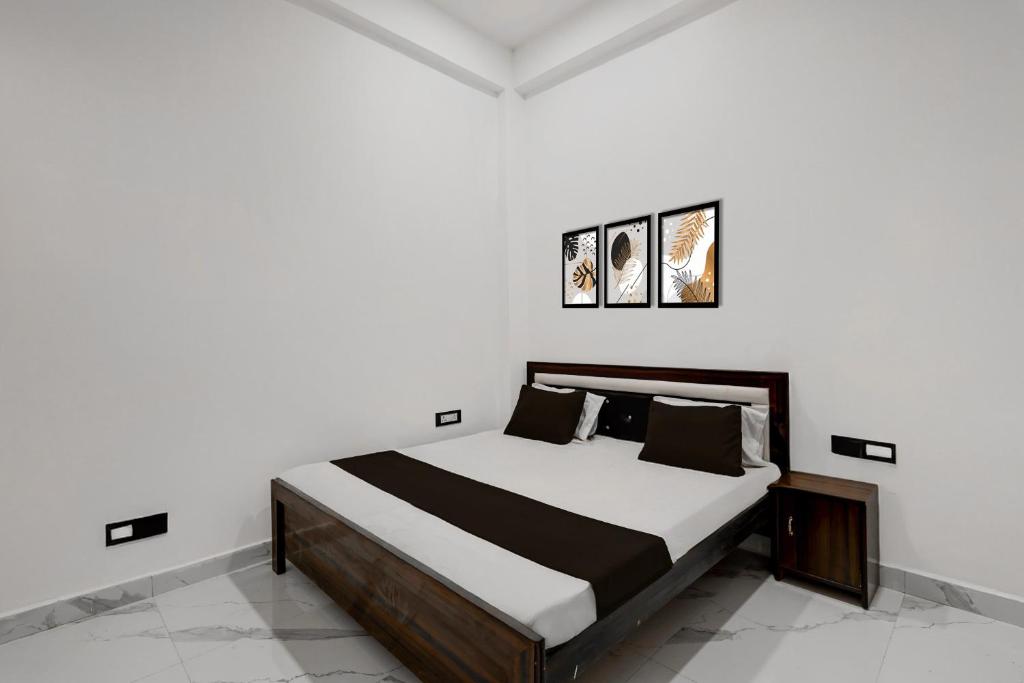 a bedroom with a bed with white walls at SPOT ON Galaxy Hotal in Prayagraj
