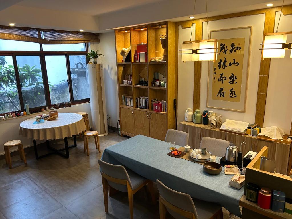 a dining room with a table and a table and chairs at 闲山民宿 CosyValley Inn in Hangzhou