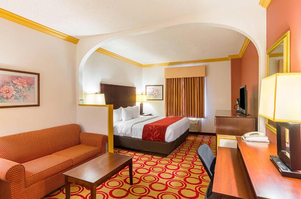 a hotel room with a bed and a couch at Quality Suites Lubbock Southwest in Lubbock