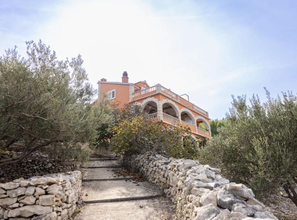 a house on a hill with a stone wall at Apartments Sea Line in Prigradica