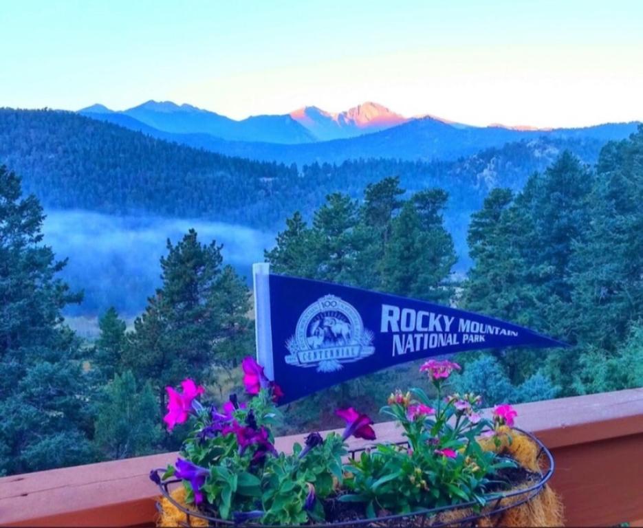a sign for the rocky mountains national park with flowers at Rocky Mountain Panorama Cabin in Estes Park