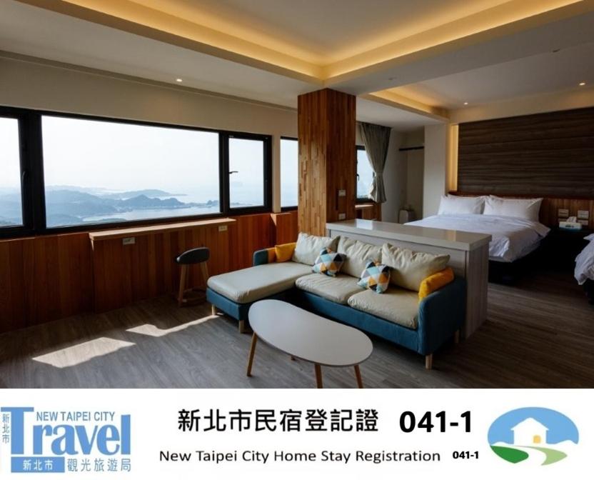a hotel room with a bed and a couch at 九份觀海樓民宿 in Jiufen